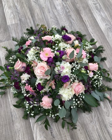 pink and purple posy display - fuberal tribute posy design - pink roses germini freesia - purple lisianthus - limonium - ivory hydrangea gypsophilia
