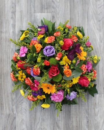 vibrant posy display - funeral tribute posy design - germini - lisianthus - rose -xanths - yellow pink purple and orange flowers 