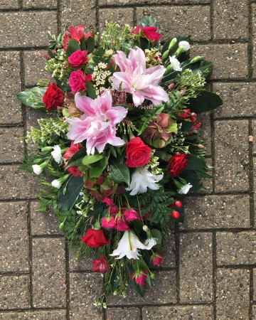 pink cerise and red single ended spray funeral tribute design - pink double lily - cerise rose and spray rose - red rose and alstromeria - ivory carnation and waxflower 