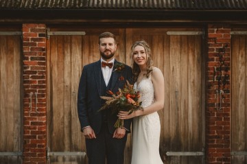 Autumnal wedding at shustoke farm barns - Orange gold navy and nude wedding flowers - quicksand roses - orange roses - blue vibernum - crocosmia - gold fern - floral arch - table plan flowers - wedding cake flowers 