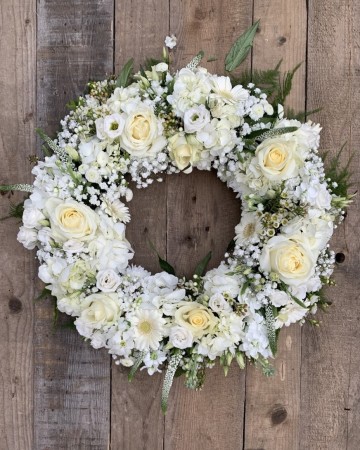 compact wreath design full of hydrangea, roses, gypsophilia, veronica, lisianthus and germini