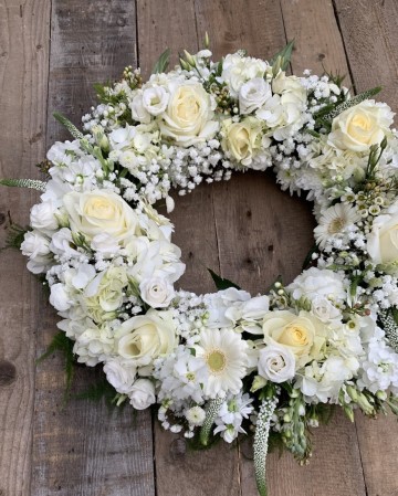 compact wreath design full of hydrangea, roses, gypsophilia, veronica, lisianthus and germini