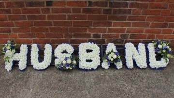 funeral tribute letters - husband based in white chrysanthemum with royal blue ribbon edge and blue and white sprays 