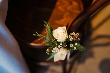 rose and foliage display tied to chairs to line aisle and top table at wedding breakfast 