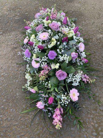 Casket spray of lilac and purple flowers 