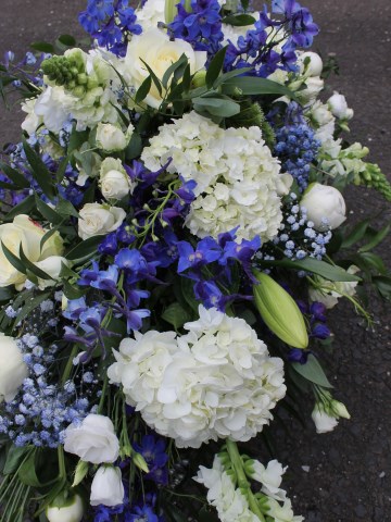 casket spray in royal blue and white colours - BCFC colour funeral tribute